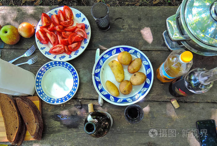 夏季蔬菜和葡萄酒在木桌上的乡村晚餐照片