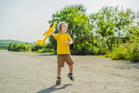 快乐的孩子在旧跑道背景下玩玩具飞机. 和孩子们一起旅行的概念.照片
