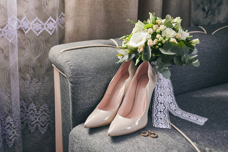 新娘的配饰，如鞋环和花束躺在沙发上