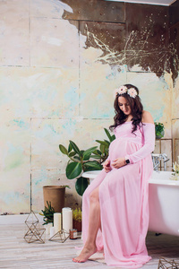 怀孕的妇女在粉红色的蕾丝礼服图片