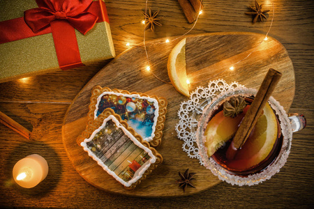 传统的圣诞节热饮覆盖红酒香料，饼干和水果在木制的乡村餐桌上。