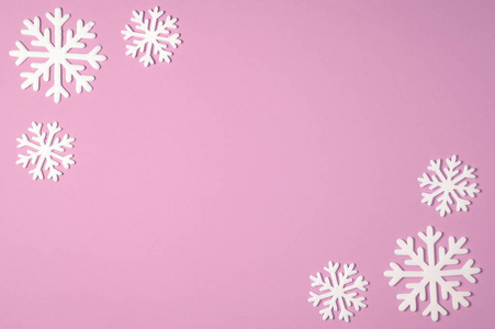 圣诞雪花边框在粉红色的背景。圣诞节最小的纹理与复制空间。顶视图