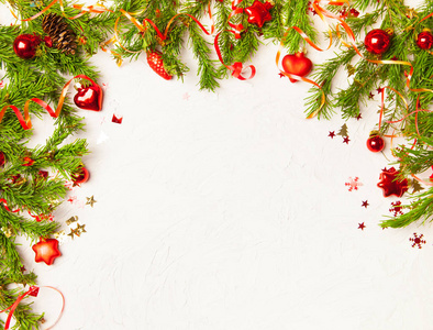 圣诞节或新年背景杉树树枝，红色玻璃玩具，白色木制背景上的装饰品。