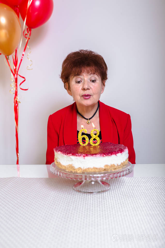 在家里庆祝生日的时候,老太太在生日蛋糕上吹蜡烛