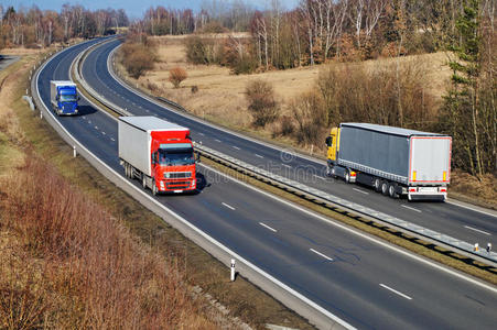 景观有高速公路，高速公路上有三辆卡车