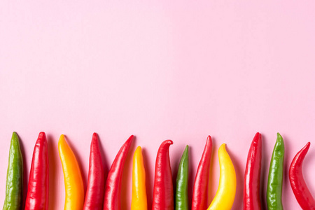 辣椒在粉红色背景上的创意布局。 最小的食物概念。