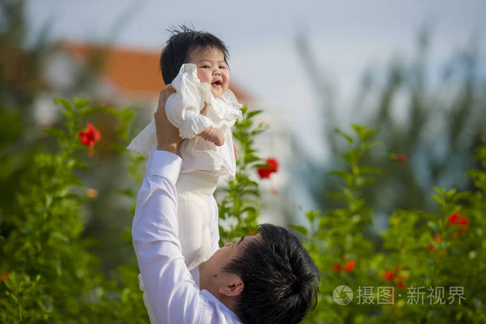 年轻,快乐,骄傲的男人,作为可爱的小女孩的父亲,抱着她的女儿在假日