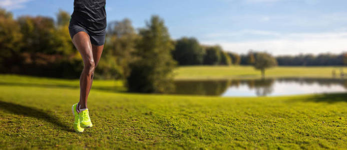 活跃的生活方式跑步者在大自然中慢跑。 年轻合身的女人跑绿色公园背景细节女孩腿横幅复制空间