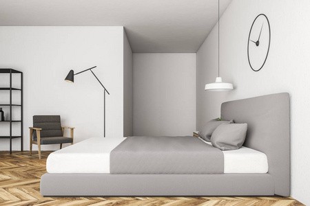 梳妆台侧面主卧室内部的侧面视图,白色墙壁,木制地板,有灰色盖子的床