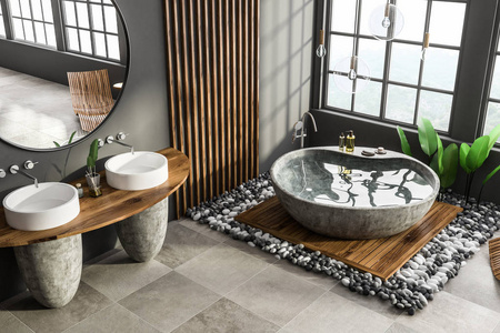 现代浴室的角落，灰色和木制墙壁，瓷砖地板，石浴缸和双沉池与圆形镜子。3D渲染
