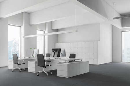 开放空间办公室的角落,白色的墙壁,灰色的地板,巨大的白色电脑桌和储