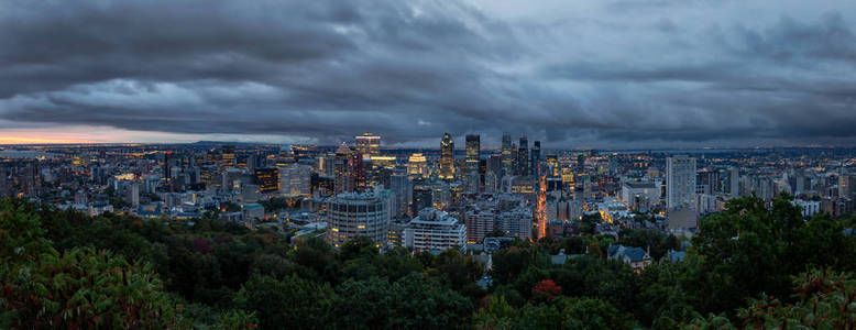 在一个引人注目的多云日出期间，一个美丽的现代市中心城市的空中全景。 摄于加拿大蒙特利尔皇家山。