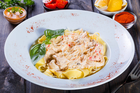 海鲜鱿鱼环虾贻贝牡蛎番茄帕尔马干酪罗勒和奶油酱盘在深色木制背景下的意大利菜。 餐桌上的配料