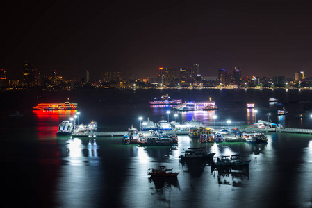 船和渡船芭堤雅市码头湾夜间与城市天际线背景泰国