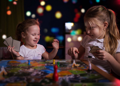 棋盘游戏概念。两个小女孩在家玩棋盘游戏。 猜一猜A.游戏B.游戏C.游戏D.游戏D.游戏D.游戏D.游戏D.游戏D.游戏D.游戏