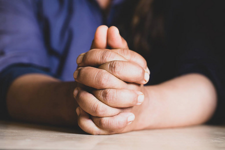 双手交叠在祈祷圣经上,在教堂的概念,信仰,螺旋和宗教照片