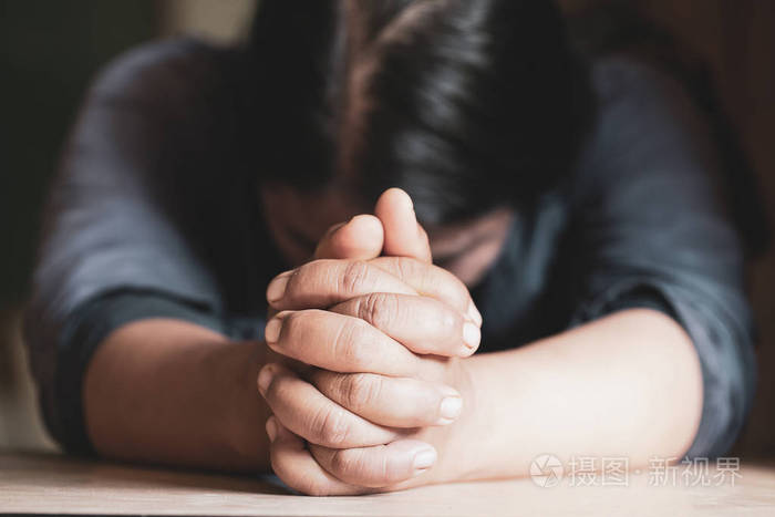 双手交叠在祈祷圣经上,在教堂的概念,信仰,螺旋和宗教