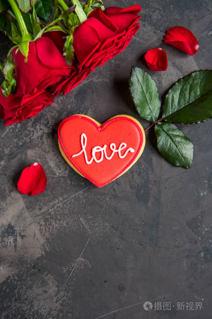 红色玫瑰和饼干形状的心与文字爱黑暗的背景复制空间