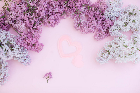 丁香枝和两个粉红色的心在一个浅粉色背景空空间为您的文本, 顶部视图。一颗又大又小的心像 simbol 的爱
