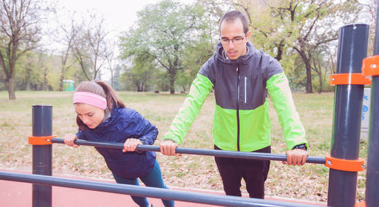 运动的男人和女人在公园做热身运动。 适合年轻夫妇在秋天早上在大自然中训练。