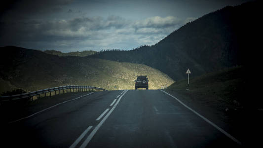 阿尔泰自然的美丽景色和景观。 阿尔泰的道路和公路的视角，背景是雄伟的山脉，覆盖着森林和天空，云层。