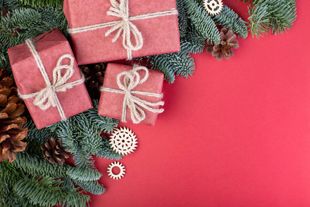 圣诞作文圣诞节红色装饰, 冷杉树枝与玩具礼品盒在红色背景。平面布局顶部视图复制空间