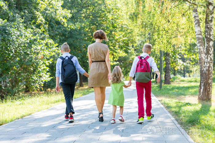 快乐的年轻家庭, 母亲带着三个孩子走在公园里.健康的生活方式理念