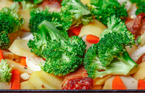 烤土豆胡萝卜西兰花绿在木桌上。 健康素食