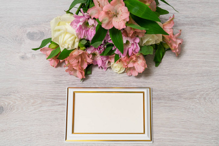 五颜六色的玫瑰花束，菊花和紫藤花，木制背景上有空的相框