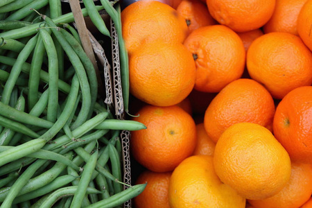 多种绿色新鲜的有机串豆和多汁的明亮橙色图案背景