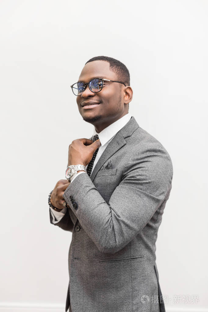 年轻的非洲裔美国商人穿着灰色西装绑在白色背景上的领带