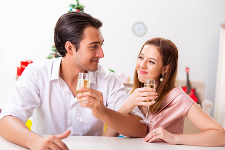 年轻夫妇 celebraring 圣诞节与香槟