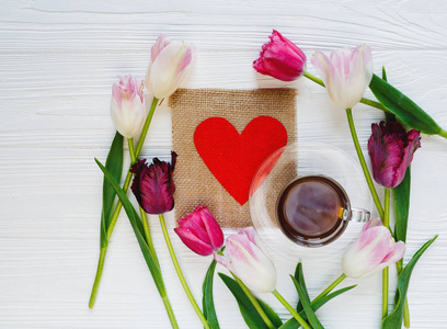 五颜六色的美丽郁金香和一杯咖啡在中间的白色木桌上。情人节，春天的背景。花卉模拟。母亲节快乐，浪漫的静物，鲜花