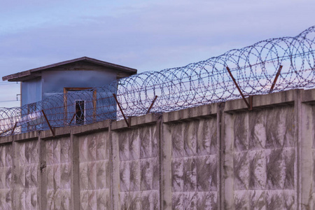 守卫塔和带刺铁丝网的监狱或封闭地区的栅栏照片