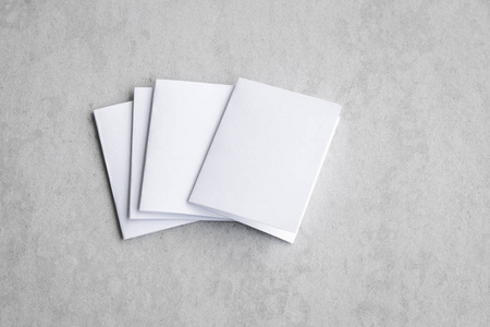 空白肖像模拟纸。 小册子杂志孤立在灰色多变的背景白纸上孤立在灰色水泥背景上。