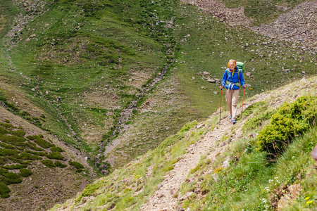 快乐的女人徒步旅行在安德拉和西班牙的比利牛斯山。 北欧步行娱乐和徒步旅行沿G R11小径