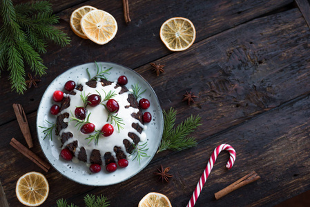 圣诞布丁水果蛋糕装饰有糖霜和蔓越莓在乡村木桌上复制空间顶部视图。 自制传统圣诞甜点圣诞布丁。