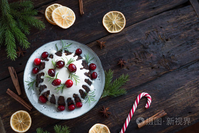 圣诞布丁水果蛋糕装饰有糖霜和蔓越莓在乡村木桌上复制空间顶部视图.