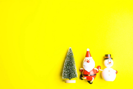圣诞节时，小雪人和小圣诞老人被隔离在黄色背景上。