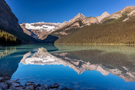 加拿大班夫国家公园的迷人湖光倒影，背景是雪和蓝天