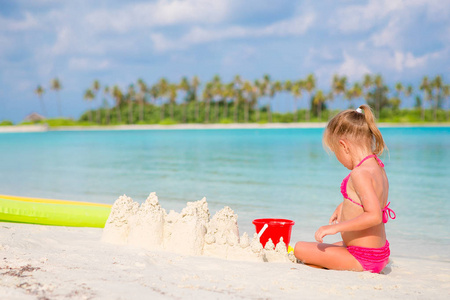 可爱的小女孩，在热带度假期间玩沙滩玩具