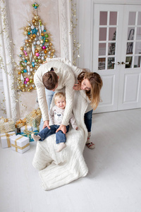 家庭的幸福肖像父亲, 怀孕的母亲和他们的小儿子。新年快乐。装饰圣诞树。圣诞节早晨在明亮的客厅里
