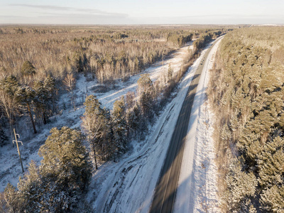 冬季道路上的汽车雪覆盖树木鸟瞰图