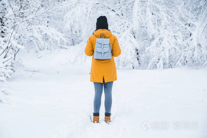 站在雪地森林里展望未来的女人从后面看复制空间