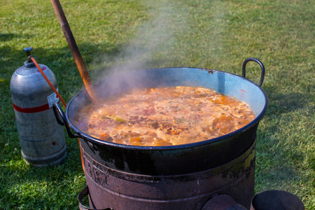 在大型金属锅锅里用煤气篝火在室外准备传统的乌克兰汤罗宋汤