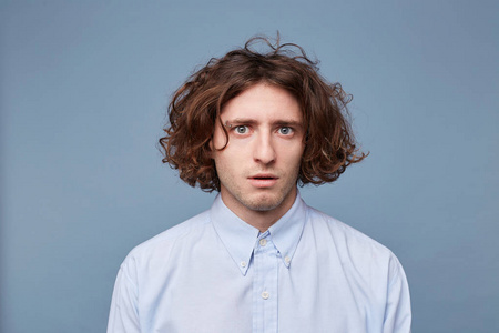 嘴部一个看起来害怕的年轻人目瞪口呆地站着,他的嘴部分地张开了.