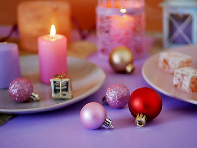 装饰构图，粉红色，从燃烧蜡烛，装饰灯笼，东方糖果，盘子，圣诞节装饰球，浅银背景，浪漫气氛，季节性寒假。