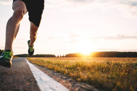 快速强壮的跑步者脚在沥青路上跑步,在运动鞋上特写.