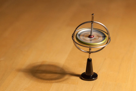 木桌上的陀螺仪旋转和平衡照片