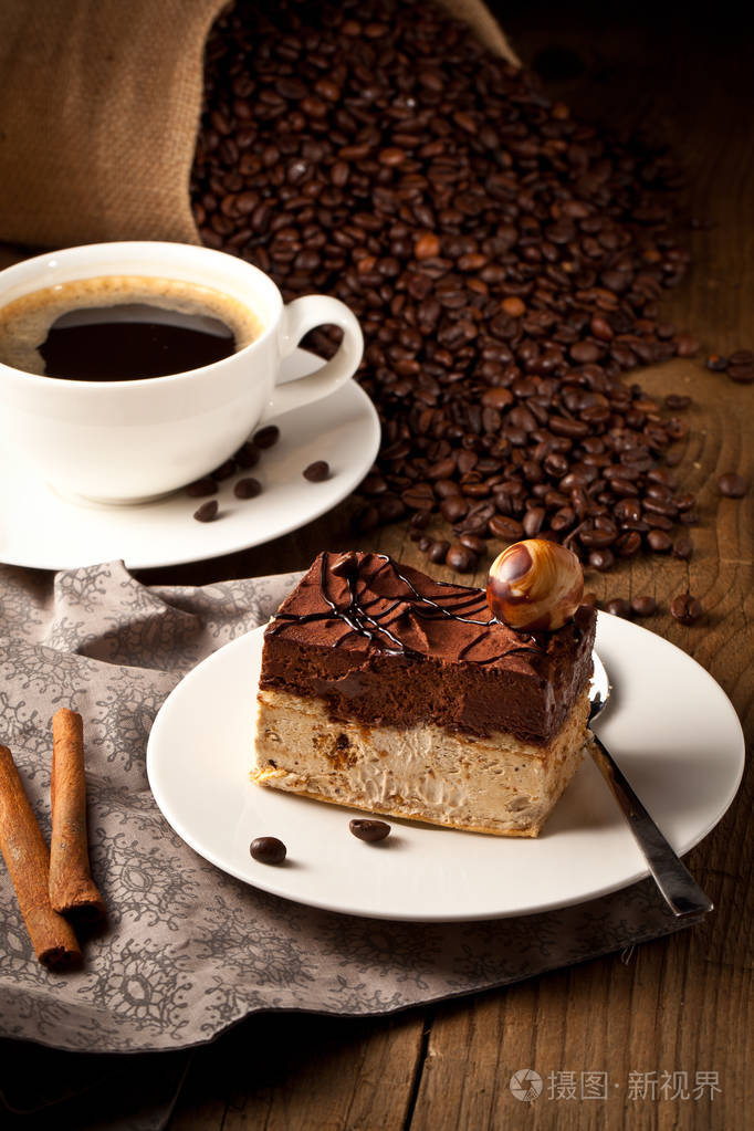 木桌上的巧克力蛋糕和咖啡杯
